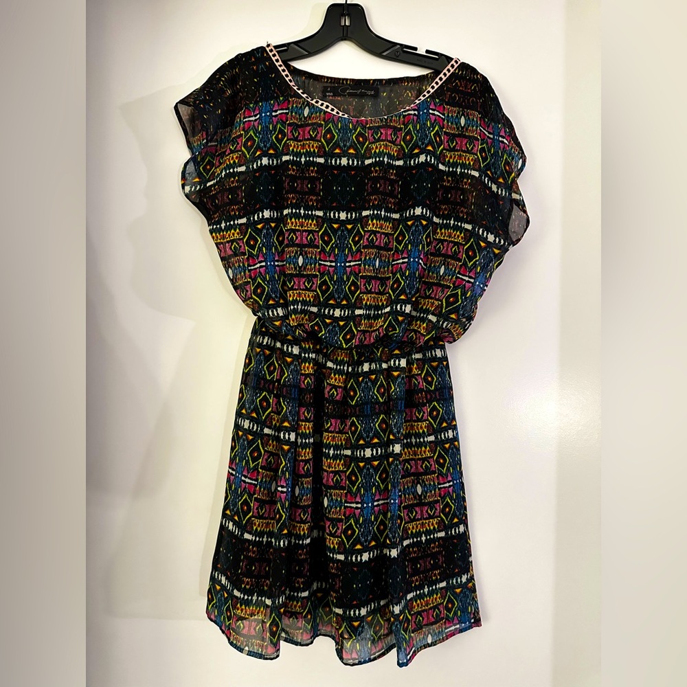 Flowy mini dress, black with vibrant geometric pattern, ribbon trim